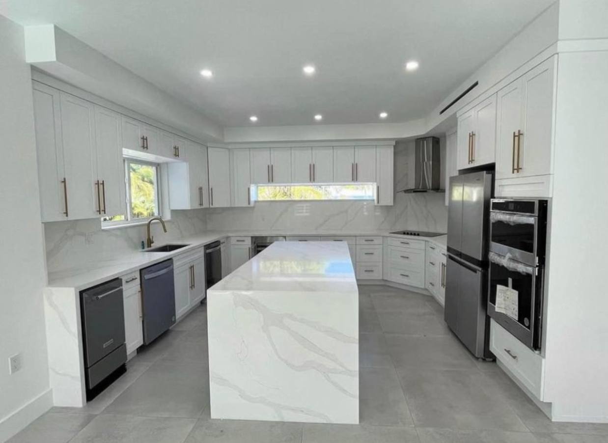 White shaker kitchen with marble waterfall island
