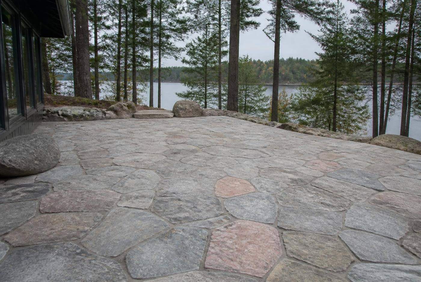 Natural stone interlock driveway winding through pines at a Muskoka cottage entrance