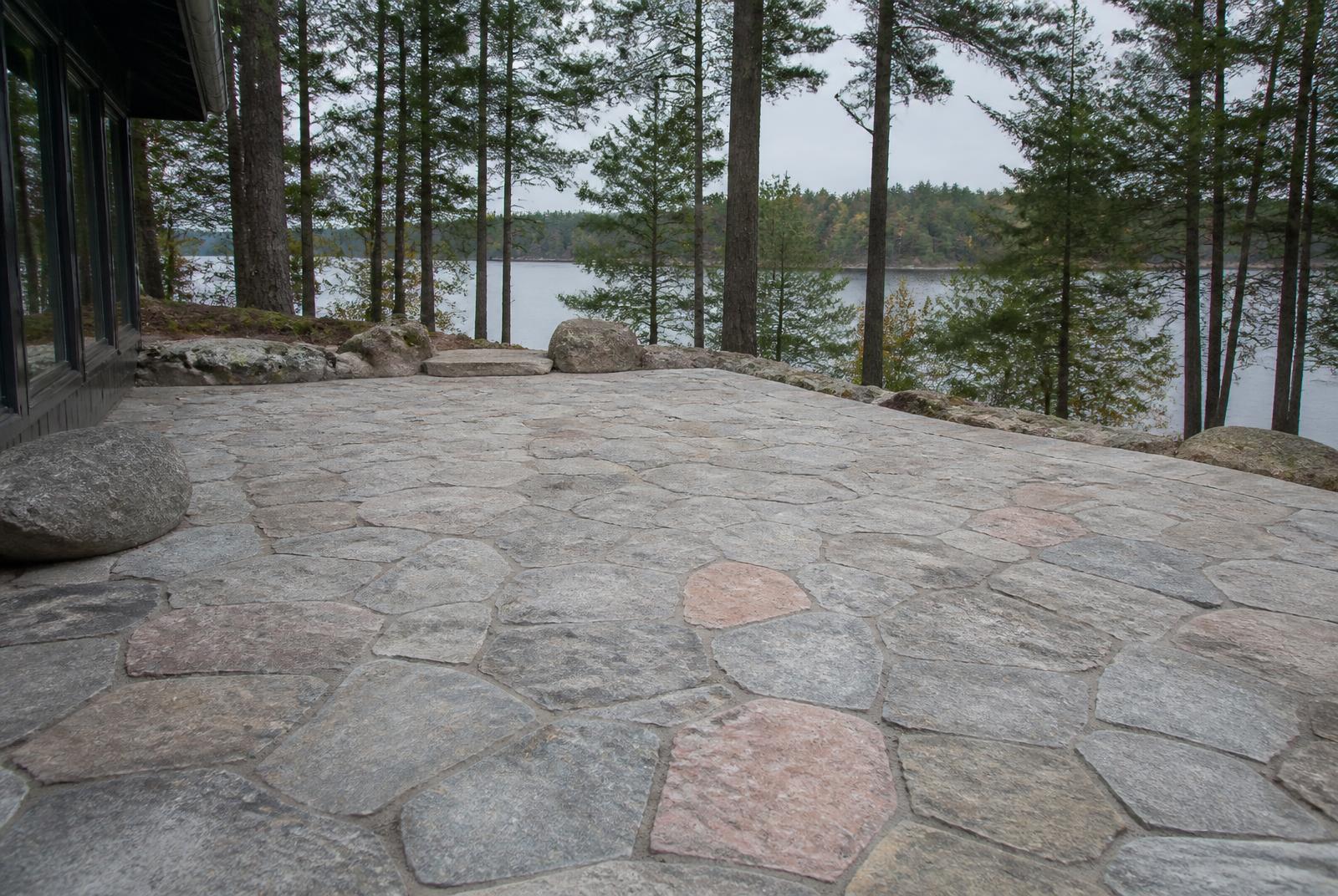 Natural stone interlock driveway winding through pines at a Muskoka cottage entrance